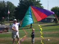 Montreal back pain free grandpa and grandson playing with a kite